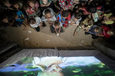 Children gather at a makeshift cinema set up among the tents of the Rafah refugee camp. EPA