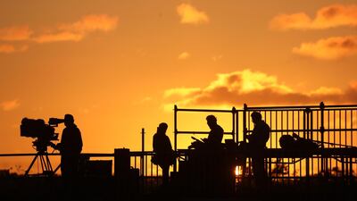 Jounalists wait for the arrival of French President Emmanuel Macron during sunset at Ezeiza airport. AFP