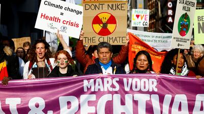 Activists march in Amsterdam to demand urgent climate action during the campaign's final stretch. Reuters