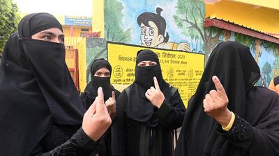 Women display indelible ink marks after casting their votes for state elections in Bhopal, Madhya Pradesh, on Friday. AP