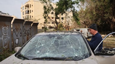 A Lebanese man inspects a damaged car on Wednesday after Israeli strikes on Beirut. AFP
