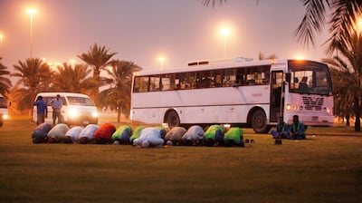 Construction workers pray in a rest area not far from Abu Dhabi's Grand Mosque after a long shift. Jeff Topping / The National