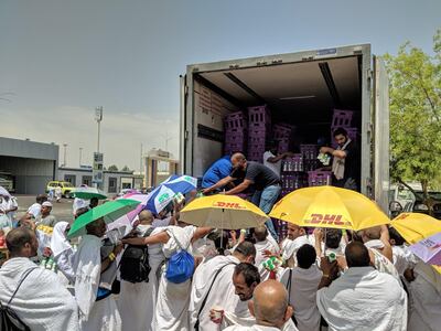 Men distribute buttermilk to thirsty pilgrims.