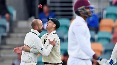 Australia's Nathan Lyon, left, and Adam Voges celebrate the dismissal of Marlon Samuels, right, during Day 2 of the first Test in Hobart on Friday. William West / AFP / December 11, 2015