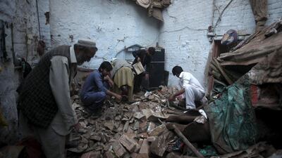 Residents search for belongings in the rubbles of a house in Peshawar. Fayaz Aziz / Reuters