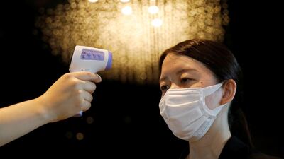 A woman has her temperature checked by a hotel worker in Tokyo, Japan. Reuters