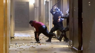 Riot police chase an anti-government protester. AFP