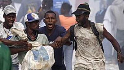 Looters fight for a bag of materials in the Haitian capital Port-au-Prince on Saturday.