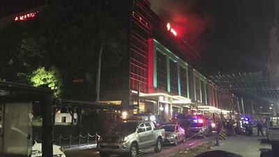 Emergency responders and security officials are seen parked outside the Resorts World Manila complex early on June 2, 2017, as smoke rises from the building. Bullit Marquez / AP Photo