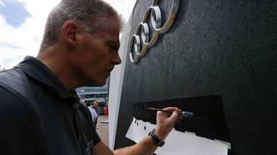 An employee paints at the Audi booth. Audi is planning cost custs by 2022 to help fund a shift to electric cars. Ralph Orlowski / Reuters