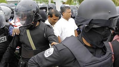 Police arrested last year the former Maldives president Mohamed Nasheed, centre left, the country's first democratically-elected president, after he failed to turn up for the start of a trial for abuse of power. Ho / AFP