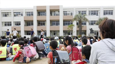 Students sit on a playground after they were evacuated from school building after an earthquake at Ikeda elementary school in Ikeda, Osaka. Reuters