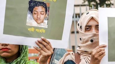 Women hold up signs with a photograph of Nusrat Jahan Rafi at a protest in Dhaka on April 12, 2019, days after she was set on fire for reporting sexual harassment. AFP