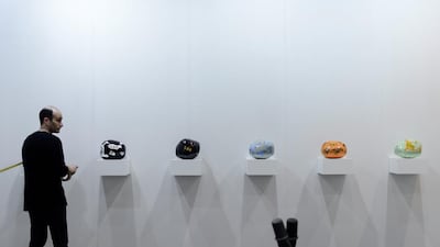 A man sets up an artwork at a booth of the Art Basel venue in Hong Kong. Hong Kong Art Basel brings together 245 participating galleries - half from Asia and Asia-Pacific. AFP PHOTO / Philippe Lopez