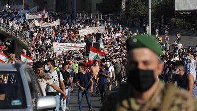Lebanese army vehicles escort crowds walking over a bridge linking the city on the first anniversary of anti-government protests. Getty Images
