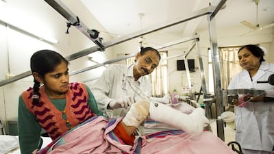 Ward sister Prem Wati attends as Dr Varghese examines Mustareen Khan.