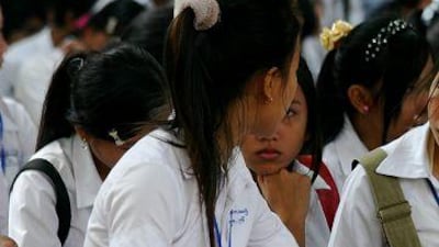 Students look through Cambodia's first textbook of Khmer Rouge history, which was issued to them earlier this week.