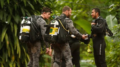 Australian Federal Police and Defence Force personnel talk to a Thai rescuer, right, before diving after the 12 boys and their football coach were found alive, in Mae Sai, Chiang Rai province, in northern Thailand. Sakchai Lalit / AP Photo