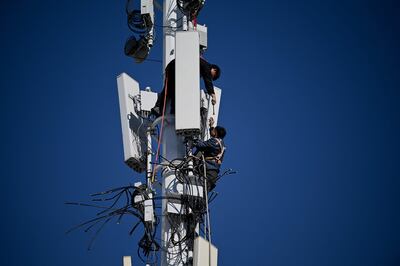 Workers on a 5G tower at Shougang Park, one of the sites for the Beijing 2022 Winter Olympics. Photo: AFP