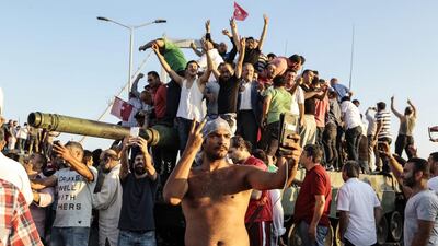 Supporters of Turkish president Recep Tayyip Erdogan wave flags after soldiers involved in the coup surrendered on Istanbul's Bosphorus bridge on July 16, 2016. Gokhan Tan/Getty Images
