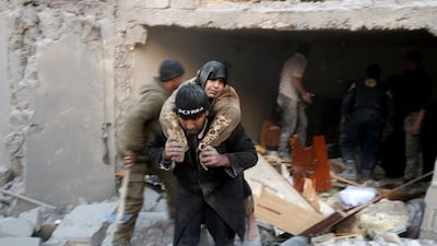 A Syrian rescuer carries a woman who was found alive in the rubble of a building in Aleppo's rebel-held district of Al Hamra on November 20, 2016. Thaer Mohammed / AFP