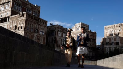 Yemenis walk past historic buildings amid the ongoing coronavirus pandemic in the old quarter of Sanaa. EPA
