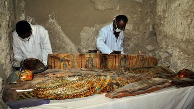 Members of an Egyptian archaeological team work on a wooden coffin discovered in a 3,500-year-old tomb in the Draa Abul Nagaa necropolis, near the southern Egyptian city of Luxor. AFP