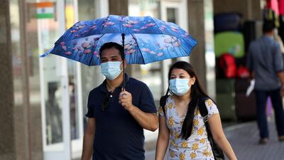 People wear masks to curb the spread of the coronavirus in Satwa, Dubai. Chris Whiteoak / The National