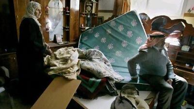Palestinians survey the damage after their home was ransacked by Israeli soldiers in the West Bank hamlet of Awarta.