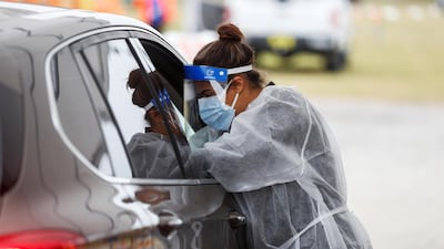 A medical worker talks to a person in a car as people line up at a coronavirus vaccination site at Strawberry Festival Fairgrounds in Plant City, Florida, US. Reuters