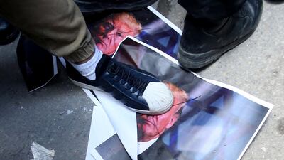 Palestinian protesters tread on a picture of US president Donald Trump during a protest in the West Bank City of Nablus on December 7, 2017. Alaa Badarneh / AFP