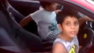 A screenshot taken from a Youtube video of a boy driving his dad's Ferrari in India. The father has been charged by police in Kerala with endangering the life of a child and allowing a minor to drive.