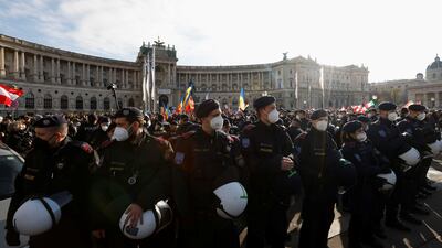 Police officers stand guard as demonstrators gather to protest against the Covid-19 measures in Vienna. Reuters
