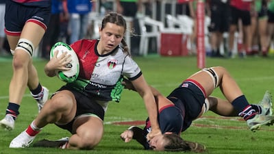 A Dubai College player lands awkwardly when attempting to tackle a Harlequins player.