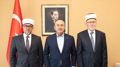 Turkish Foreign Minister Mevlut Cavusoglu, centre, meets Muslim clerics Ahmet Mete, left, and Ibrahim Serif in Komotini, Greece. Reuters