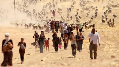 Displaced Yazidis, fleeing violence from forces loyal to ISIS in Sinjar town, walk towards the Syrian border, on the outskirts of Sinjar mountain, near the Syrian border town of Elierbeh of Al Hasakah governorate, Iraq August 10, 2014. Reuters