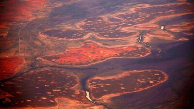 A small river flows amid sand dunes.