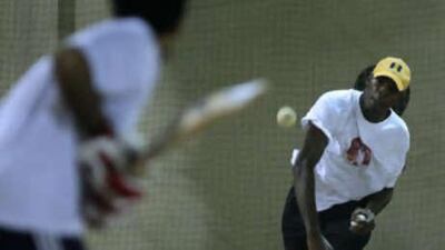 The UAE cricket team coach Vasbert Drakes throws a ball to Mohammed Tauqir during practice at Sharja Cricket Stadium.