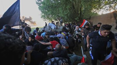 Iraqi protesters flee from security forces during a demonstration against state corruption, failing public services, and unemployment, in the Iraqi capital Baghdad's central Khellani Square. AFP