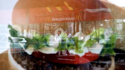 People are reflected in a window of a closed McDonald's branch in Moscow, one of four temporarily closed by Russia's food safety watchdog. Maxim Zmeyev / Reuters