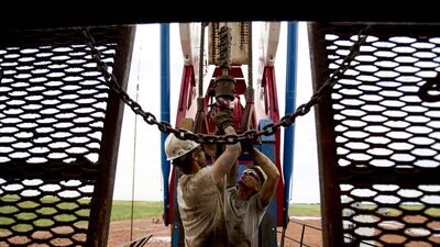 Above, workers on a US oil derrick in North Dakota. Gregory Bull / AP Photo