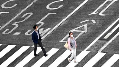 People wearing face masks amid concerns of the coronavirus cross a street in Tokyo. AFP