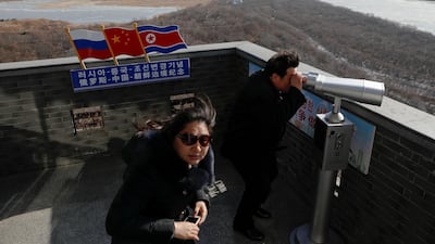 A tourist uses binoculars to look across to North Korea from the town of Hunchun in China. Damir Sagolj / Reuters