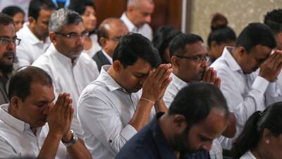 People pray at the multi-religious remembrance ceremony.