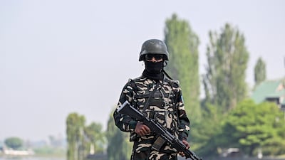 An Indian soldier stands guard on the shores of Dal lake outside a vote-counting station in Srinagar. AFP