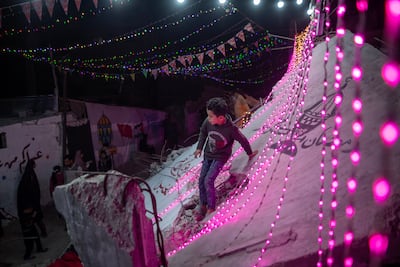 Displaced Palestinians hang decorations over the rubble of their destroyed homes. EPA