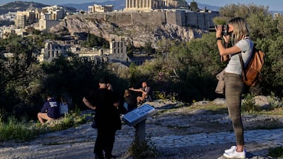 Tourists enjoy the view of the Acropolis in Athens. The Greek capital is one of the most-searched destinations for Eid Al Adha by UAE residents. AFP
