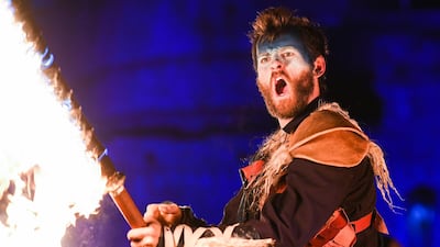 A member of PyroCeltica brandishes a flaming sword ahead of the torchlight procession. Getty