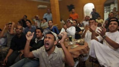 Fawzi Mohammed Nasser, from Tunisia, centre, and other football fans react to a missed Algerian goal during their match against the United States at the Aroma Cafe in Ras al Khaimah.