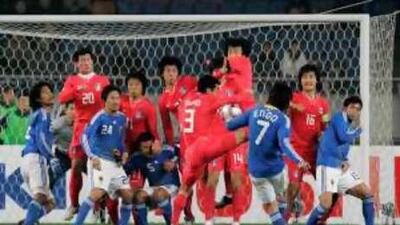 Japan's Yasuhito Endo tries to lift the ball past South Korea's imposing red defensive wall during a 1-1 draw earlier this year.